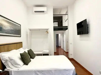 a bedroom with a bed and a tv on the wall at Trastevere Wondersuite in Rome