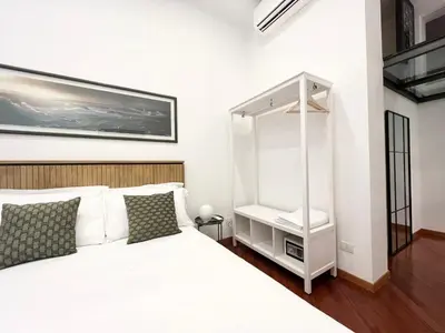 a bedroom with a white bed and a mirror at Trastevere Wondersuite in Rome