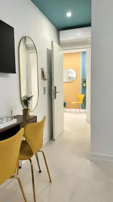 a bathroom with a mirror and a table and chairs at Vatican Lovely Nights-Luxury Rooms in Rome