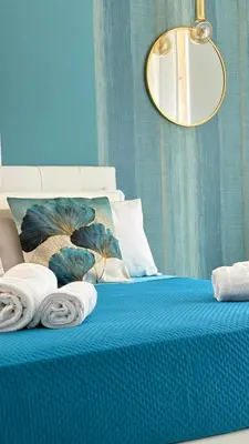 a blue bed with towels on top of it at Vatican Lovely Nights-Luxury Rooms in Rome