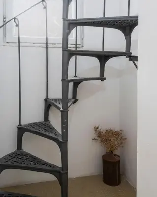 a black ladder shelf in a room with a plant at Palazzo Piazza Cavour-ZEN62 in Rome