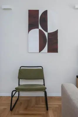 a green chair in a living room with a painting at Palazzo Piazza Cavour-ZEN62 in Rome