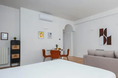 a bedroom with a bed and a table and a couch at Palazzo Piazza Cavour-ZEN62 in Rome