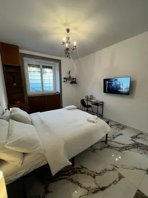 a bedroom with a bed and a tv on the wall at Escape to the Eternal City Vatican Stay in Rome