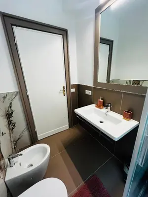 a bathroom with a sink and a toilet and a mirror at Escape to the Eternal City Vatican Stay in Rome