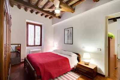 a bedroom with a large bed with a red blanket at Stunning Pantheon Apartment in Rome