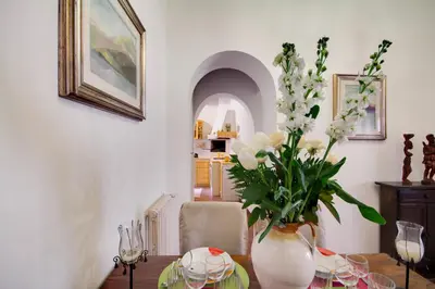 a vase with white flowers on a table at Stunning Pantheon Apartment in Rome