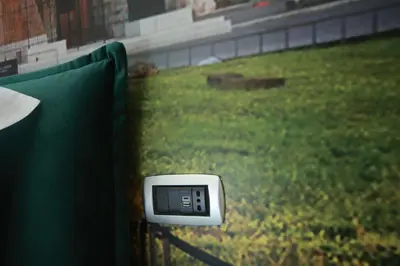 a remote control sitting on a fence with a grass field at Vacanze Romane Vaticano in Rome