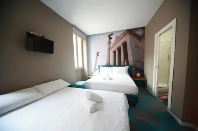 a hotel room with two beds and a flat screen tv at Vacanze Romane Vaticano in Rome