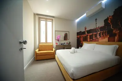 a bedroom with a white bed and a chair at Vacanze Romane Vaticano in Rome