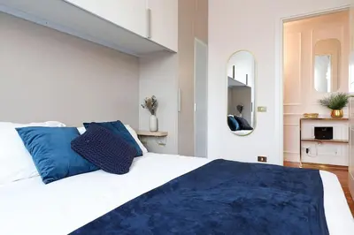 a bedroom with a large white bed with blue pillows at Jubilee Penthouse by Nosdom Properties in Rome