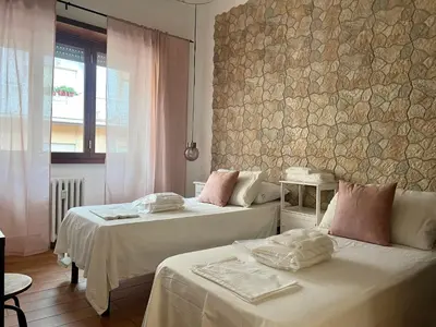 a bedroom with two beds and a stone wall at Fall in love with Roma Vaticano - 5 Minutes from the Vatican - balcony with a view in Rome