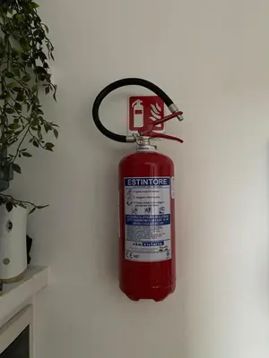 a red fire extinguisher hanging on a wall at Fall in love with Roma Vaticano - 5 Minutes from the Vatican - balcony with a view in Rome