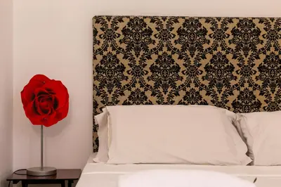 a red rose is sitting on top of a bed at iFlat Lina Cavalieri House in Rome