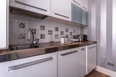 a kitchen with white cabinets and a sink at iFlat Lina Cavalieri House in Rome