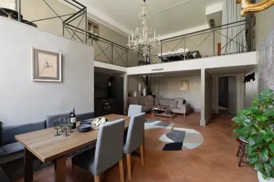 a dining room and living room with a table and chairs at Margutta Exclusive Apartment by Romeloft in Rome