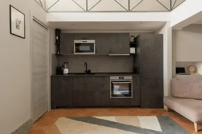 a living room with a kitchen and a couch at Margutta Exclusive Apartment by Romeloft in Rome