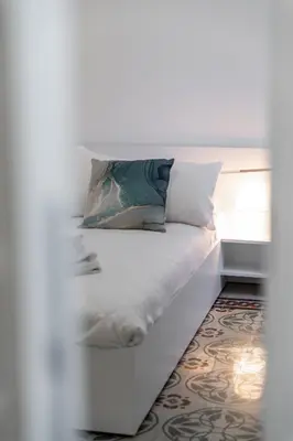 a white bed with two pillows on top of it at La Casa di Lidia - Vatican City Metro Ottaviano in Rome
