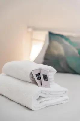 a pile of towels sitting on top of a bed at La Casa di Lidia - Vatican City Metro Ottaviano in Rome