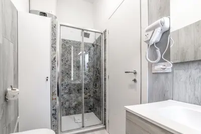 a shower in a bathroom with a phone on the wall at La Casa di Lidia - Vatican City Metro Ottaviano in Rome