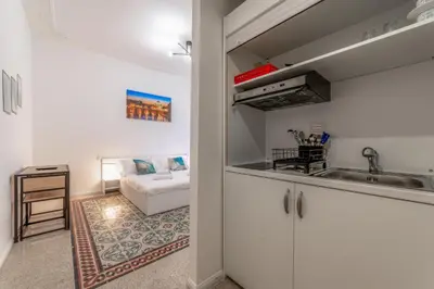 a kitchen with a sink and a couch in a room at La Casa di Lidia - Vatican City Metro Ottaviano in Rome