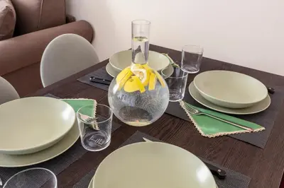 a wooden table with white plates and a vase on it at Casa Acaia by Hili in Rome