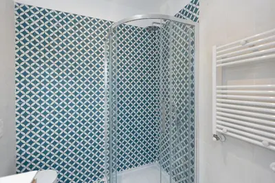 a bathroom with a shower with a blue tile wall at Mastai Trastevere Home by Rental in Rome in Rome