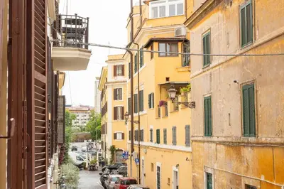 an alley in an old city with yellow buildings at Mastai Trastevere Home by Rental in Rome in Rome