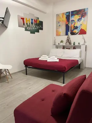 a bed in a room with a red couch at Smart Home - Trilocale con Parcheggio Privato in Rome