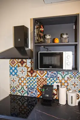 a kitchen with a counter with a microwave and tiles at Perla al Pigneto Bed and Breakfast Roma in Rome