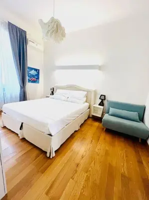 a bedroom with a white bed and a blue couch at Anna Rome Vatican Luxury in Rome