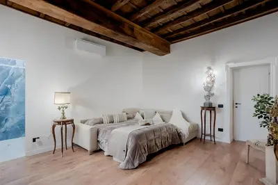a white bedroom with a large bed and wooden ceilings at Trevi Fountain Elegant Apartment in Rome