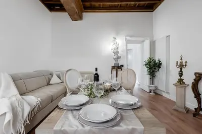 a living room with a couch and a table with plates at Trevi Fountain Elegant Apartment in Rome