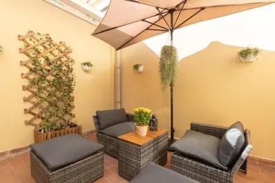 a patio with two chairs and an umbrella at Alba Terrace - Rome Modern Apt Close to Metro in Rome
