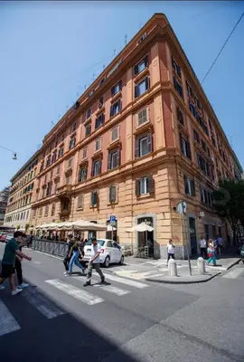 people crossing a street in front of a large building at Vatican Roof Luxury Tiffany terrasse privée in Rome