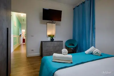 a bedroom with a bed with blue sheets and a television at Vatican Roof Luxury Tiffany terrasse privée in Rome