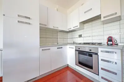 a white kitchen with white cabinets and a stove at YCH-Modern flat with terrace near Eataly in Rome