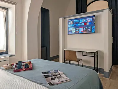 a bedroom with a bed with a television on the wall at La Corte Dei Panni in Rome