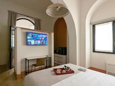 a bedroom with a bed and a table and a tv at La Corte Dei Panni in Rome