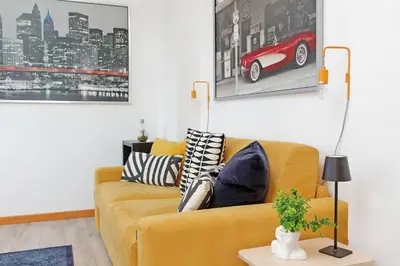 a living room with a yellow couch with pillows at Parioli Apartment self check in in Rome
