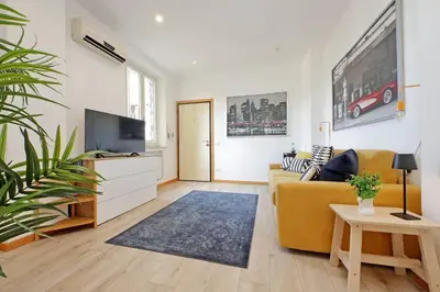 a living room with a yellow couch and a tv at Parioli Apartment self check in in Rome