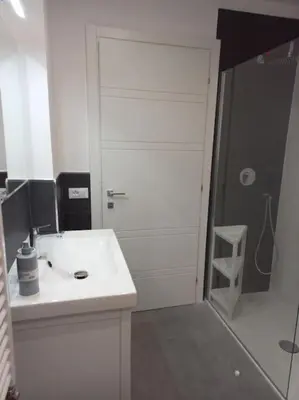 a white bathroom with a sink and a shower at Andrew's Suite Rome center in Rome
