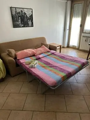 a bed sitting on a couch in a living room at Nathan House, Malatesta in Rome
