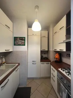 a kitchen with white cabinets and a white refrigerator at Nathan House, Malatesta in Rome