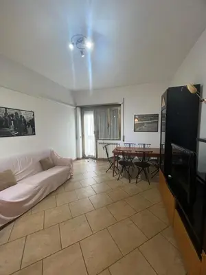 a living room with a couch and a tv and a table at Nathan House, Malatesta in Rome