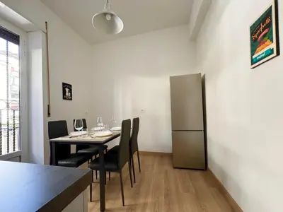 a dining room with a table with chairs and a refrigerator at House Garden 44 - 15 minutes from Vatican Museums in Rome