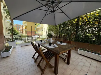 a table and chairs with an umbrella on a patio at House Garden 44 - 15 minutes from Vatican Museums in Rome