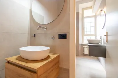a bathroom with a large white sink and a mirror at Apartment Next to St Peter in Rome
