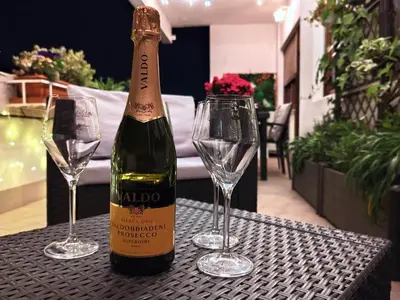 a bottle of wine sitting on a table with two glasses at La Dolce Vita Of Via Veneto - Prestigious Apartment With Wonderful Terrace In the Historic Center in Rome