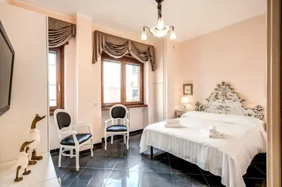 a bedroom with a white bed and two chairs at La Dolce Vita Of Via Veneto - Prestigious Apartment With Wonderful Terrace In the Historic Center in Rome